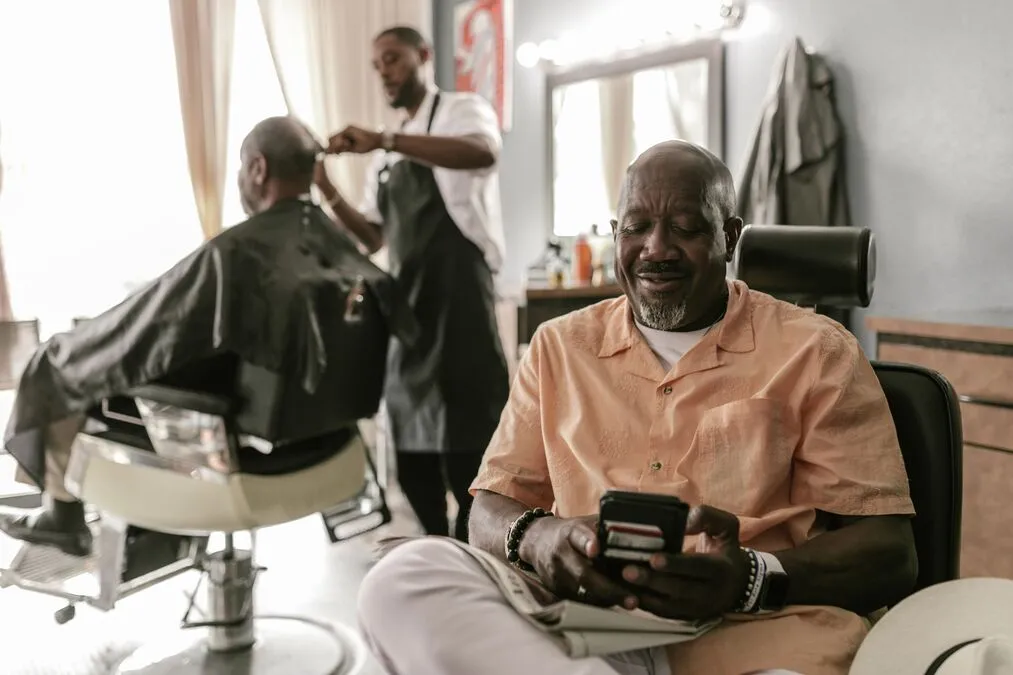 Cliente usando o celular para agendar um horário em uma barbearia